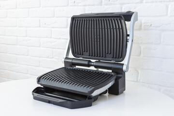 Open empty electric grill. Barbecue for home use on white kitchen background. - 368847109