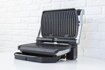 Open empty electric grill. Barbecue for home use on white kitchen background. - 368847118