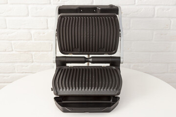 Open empty electric grill. Barbecue for home use on white kitchen background. - 368847140