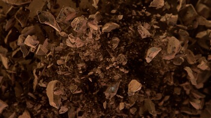 Freeze motion of flying group of raw chocolate pieces.