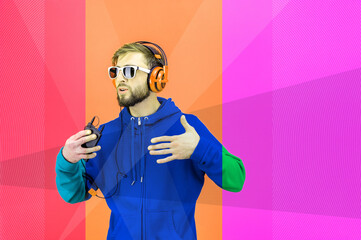 Funky young bearded hipster man in glasses and headphones dances and listens pleasurable music in his smartphone. love live. Leisure hobby mood concept. Relax.