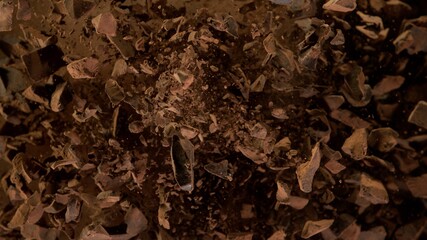 Freeze motion of flying group of raw chocolate pieces.