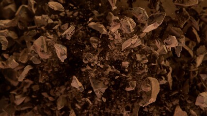 Freeze motion of flying group of raw chocolate pieces.