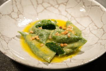 green ravioli with spinach and nuts in a plate