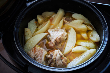 Braised potato with pieces of turkey meat with spices in a pan is ready to eat.