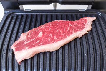 A piece of fresh meat. Juicy beef steak on the electric grill. - 368850148