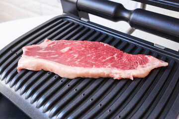 A piece of fresh meat. Juicy beef steak on the electric grill. - 368850182