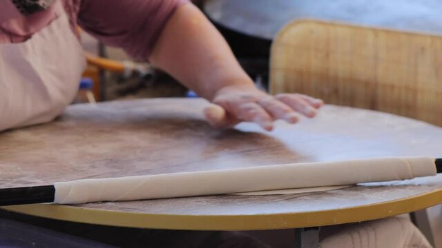 Making gozleme dough by close up female hands in kitchen. Shaping dough is precursor to making a wide variety of food stuffs, particularly breads.