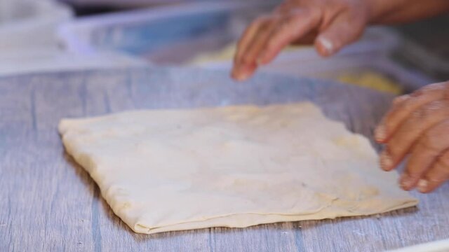 Making gozleme dough by close up female hands in kitchen. Shaping dough is precursor to making a wide variety of food stuffs, particularly breads.