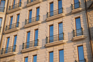 Fototapeta premium warm tones building texture with blue sky reflection in windows