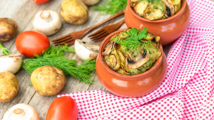 Mushrooms and potatoes cooked in clay pots in the oven.