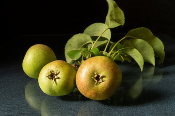 Ripe pear with green sheet rests upon table
