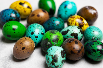 colored quail eggs on a white background