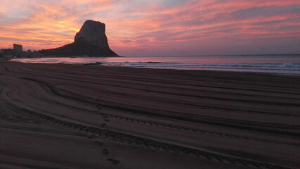 Obraz na płótnie Canvas Sunrise on the beach next to the mountain