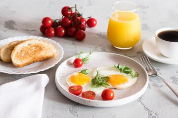 fried eggs with tomatoes and herbs, toast, coffee and juice