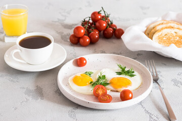 fried eggs with tomatoes and herbs, toast, coffee and juice