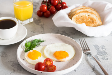 fried eggs with tomatoes and herbs, toast, coffee and juice