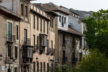 Fototapeta na wymiar Facades of old houses in the Carrera del Darro one summer morning in Granada