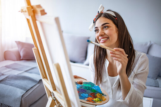 Artist lifestyle. Painting hobby. Imagination and inspiration. Talented woman creating beautiful watercolor floral design. Prifile view of female painter working in her studio
