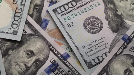 Hundred dollar bills spinning on a table. Rotation paper money close-up. Background with money american hundred dollar bills - Powered by Adobe
