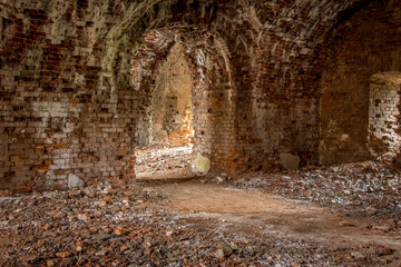Obraz premium Brick corridor on the lower level in an old abandoned and decaying building