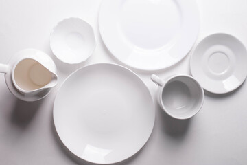 a group of different white ceramic plates on white background