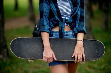 Close up of skater girl holding skateboard 