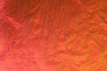 Background from purple recyclable polyethylene in neon orange light. Eco, zero waste, alternative to plastic concept. Flat lay. Horizontal. Closeup