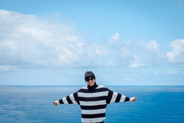 Mujer hispana de mediana edad junto al mar, pensativa mira el horizonte, asturias españa.