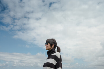 Mujer hispana de mediana edad junto al mar, pensativa mira el horizonte, asturias españa.