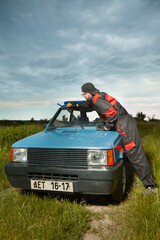 Man in overall suit take care of his lovely retro car