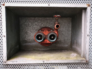 Fire extinguisher heads with water valve mounted inside box in the wall that looks like scuba...