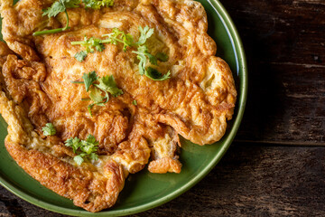 omelet in a plate on wooden table for advertisement.