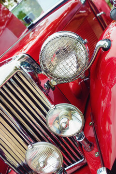 Closeup of headlights and the grille of a red 1951 MG TD classic car on October 21, 2017, in Westlake, Texas.