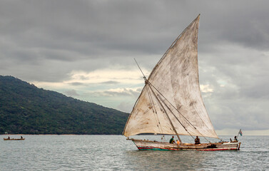 Fototapeta na wymiar NOSY BE, MADAGASCAR: Traditional sailing boat on the Indian Ocean with grey wheather.