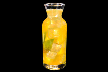 Fresh lemonade with Mango in a transparent bottle with ice with reflection, isolated on black background