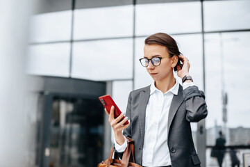 A business woman checks the time in the city during a working day waiting for a meeting. Discipline and timing. An employee goes towards a corporate meeting.