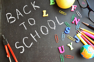 School supplies on blackboard background ready for your design top view copy space. back to school