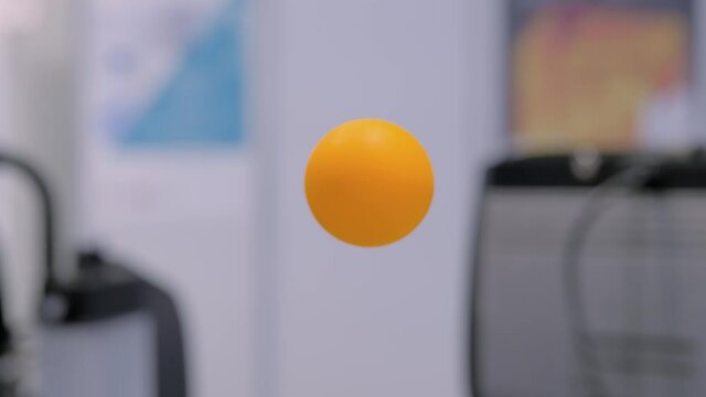 Slow motion: balancing yellow ping pong ball suspending in air stream - Bernoulli principle. interactive exposition at science museum - close up. Physics, levitation, experiment, education concept