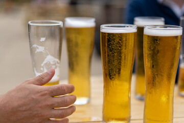 hands holding glass of beer