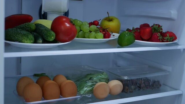 Image with a Man Opening the Refrigerator Door Looking for Fresh Fruits and Vegetables