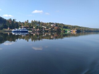 Beautiful Volga coast. Ship at the pier. A magnificent reflection in the mirror of water.