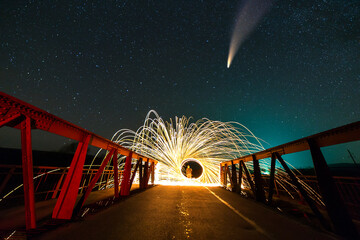 Long exposure of spinning steel wool in abstract circle making firework showers of yellow glowing...