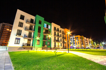 Yard between residential apartment buildings with green grass lawns and modern flat housing. Real...