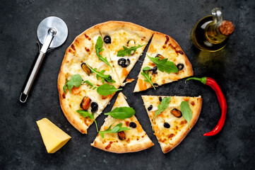 Seafood pizza with salmon, mussels, squid, olives, cheese on a stone background 