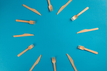 Disposable biodegradable forks and knives round border frame in blue background with copy space