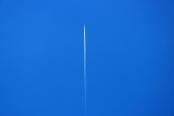 White trail of the plane on the blue sky. Airplanes in the sky. Flying plane. 