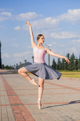 Young and beautiful ballerina posing on the street