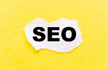 on a white piece of paper on a yellow background inscription SEO, seo search concept