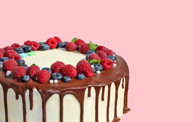 Birthday Drip Cake with chocolate ganache and berries on pink background with decor. Copy space. Celebration concept. Trendy Drip Cake.